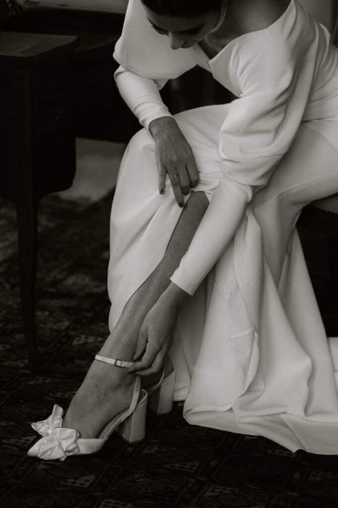 photo de mariée entour et blanc nouant sa chaussure