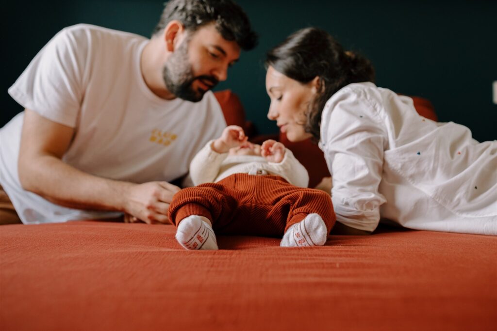jeunes parents au dessus de leur enfant lors d'une séance photo avec bébé à Bordeaux