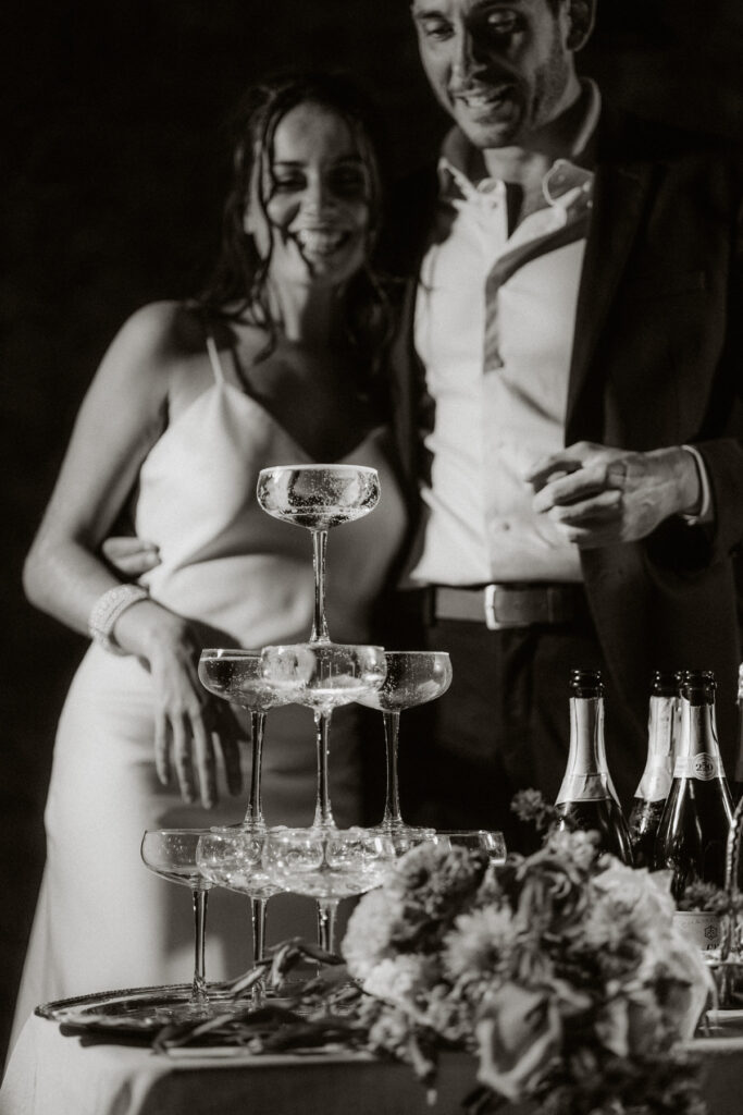 photo de mariés en noir et blanc avec une fontaine de champagne - photographe mariage