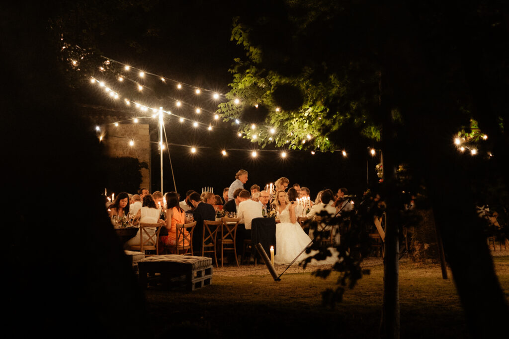 photo de nuit pendant le diner d'un mariage en extérieur en dordogne en nouvelle aquitaine avec lumière qui scintille dans la nuit - photographe mariage 