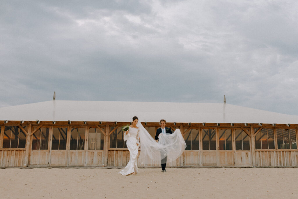 photo de jeunes mariés au cap ferret devant les cabanes bertherotte