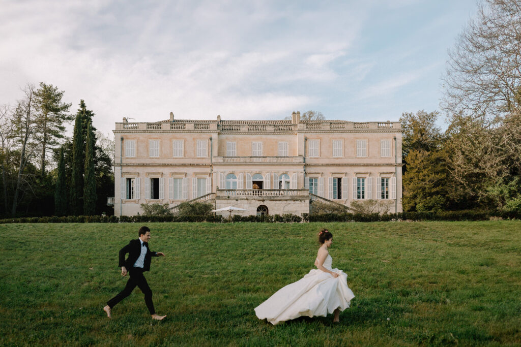 couple de mariés courant devant un chateau en dordogne - photographe mariage
