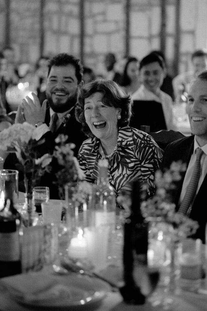 photo de la mariée du marié rigolant pendant le discours au diner - photographe mariage dordogne