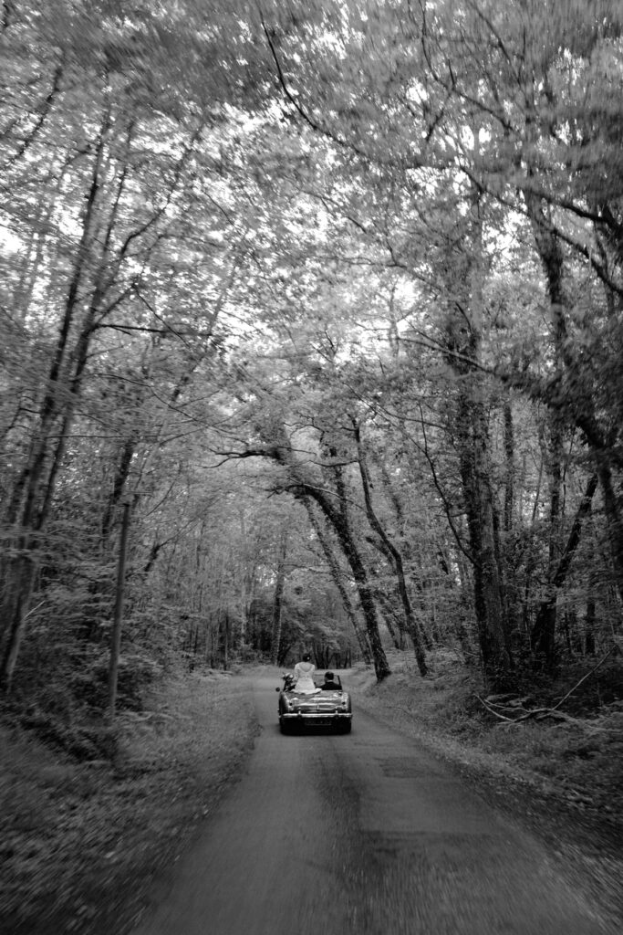 photographe mariage dordogne - photo des mariés dans la voiture en noir et blanc