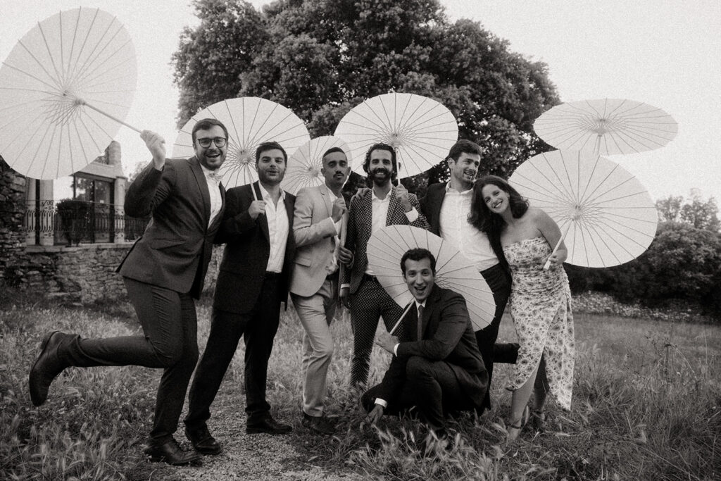 photo de groupe en noir et blanc avec ombrelles pendant un mariage à Toulouse